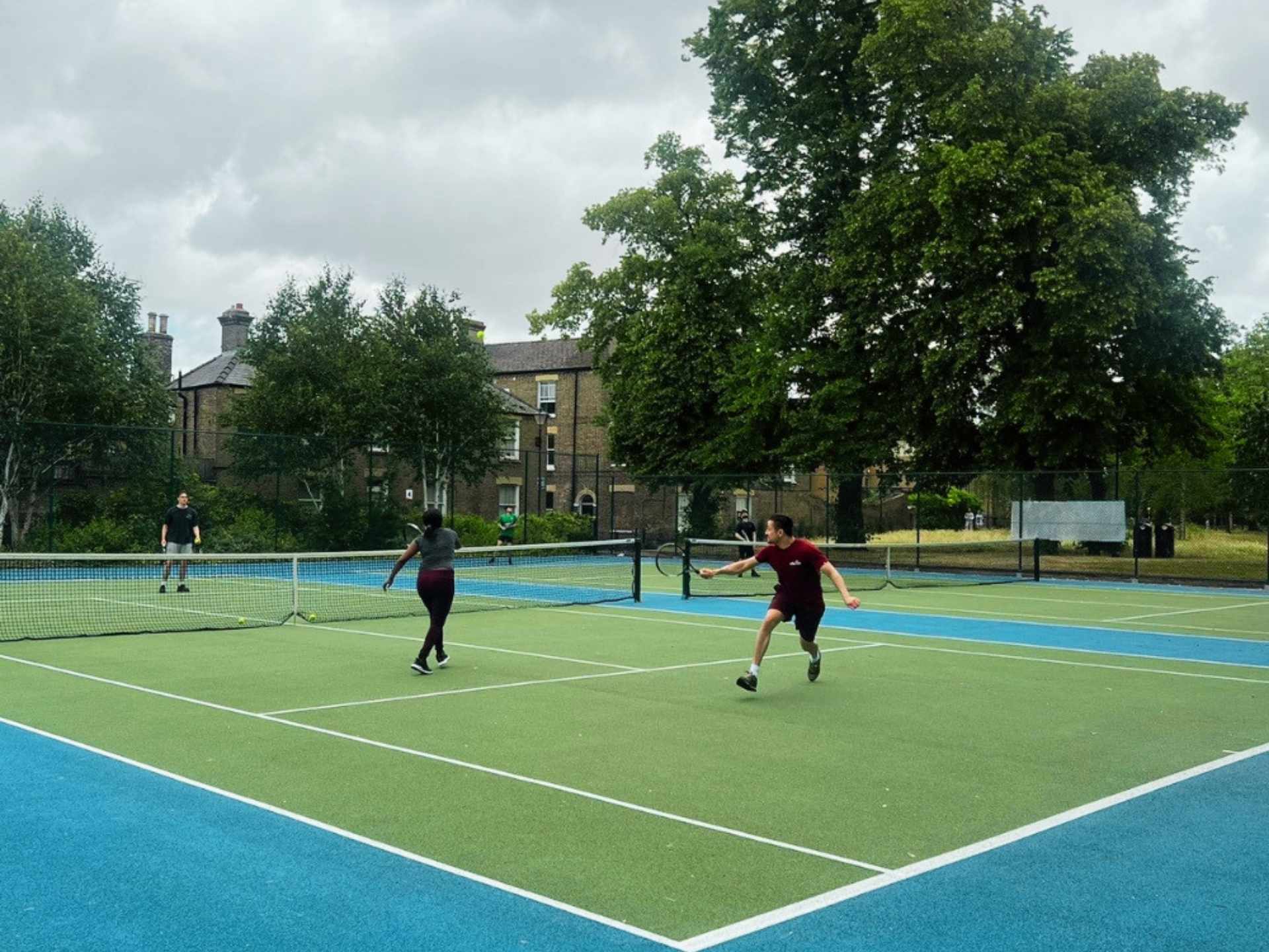 A casual tennis rally on outdoor courts in Cambridge